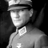 a man in a military uniform is wearing a hat and looking at the camera .