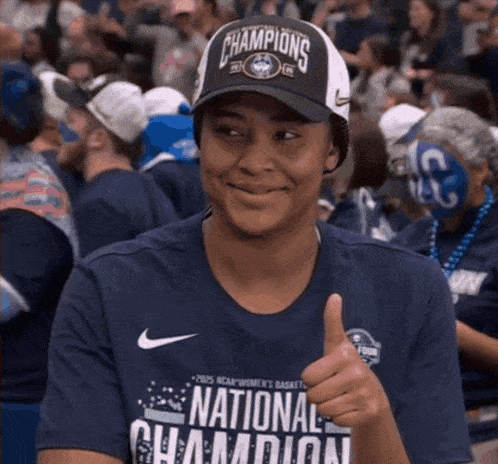 a woman wearing a hat that says national champions gives a thumbs up