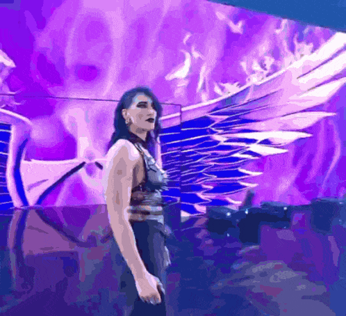 a woman standing in front of a purple background