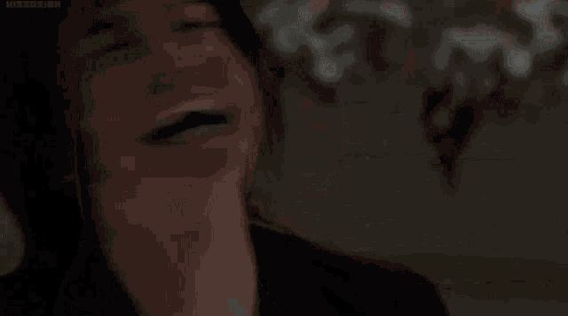 a close up of a person 's face with their hair flying in the wind .