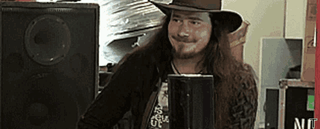 a man with long hair wearing a hat and a t-shirt that says ' i love you ' on it
