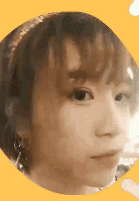a close up of a woman 's face in a circle on a yellow background