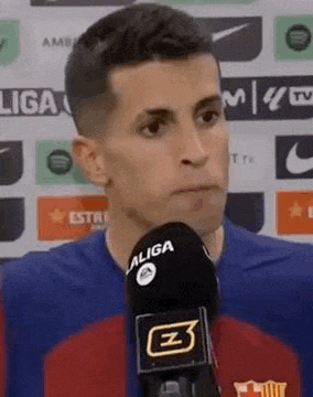 a soccer player is talking into a microphone while wearing a blue jersey .