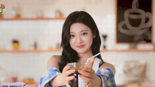 a girl is holding a cup of coffee in her hands