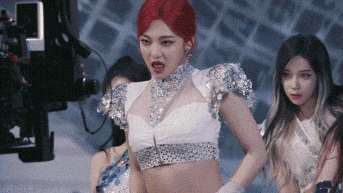 a woman with red hair is wearing a crop top