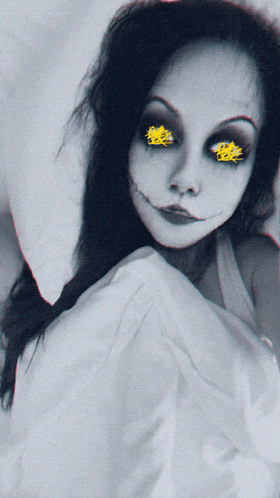 a black and white photo of a woman with a smiley face painted on her face