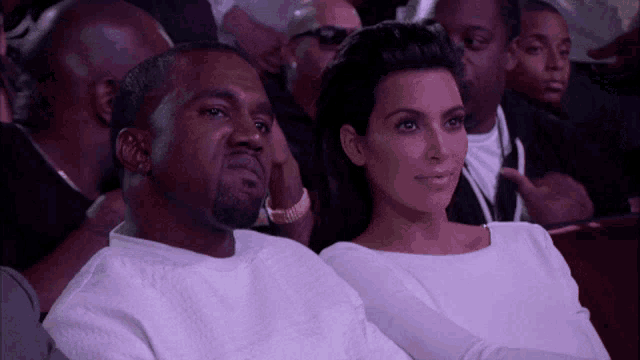 a man and a woman are sitting in a crowd watching a show