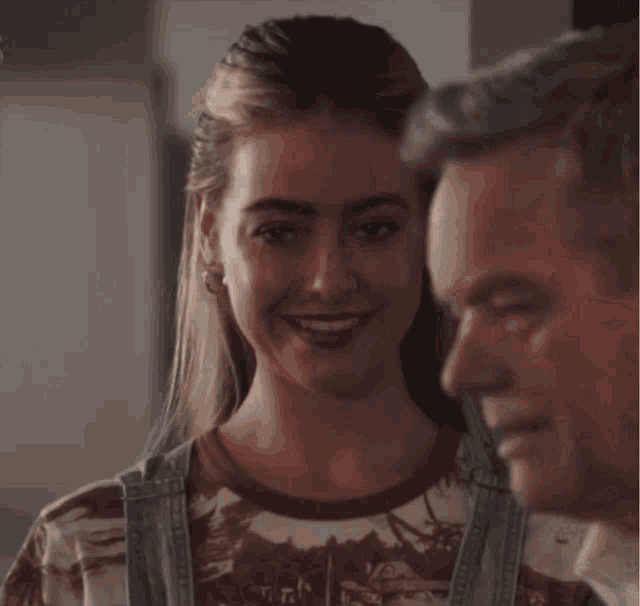 a man and a woman are standing next to each other and smiling
