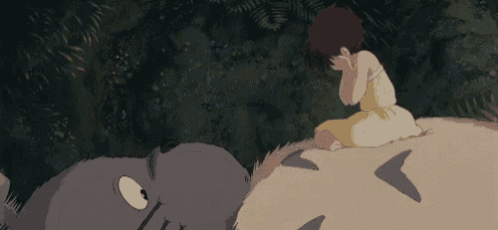 a little girl is sitting on top of a large animal in a forest .