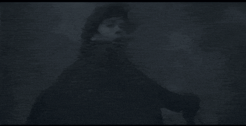 a person is standing in the fog holding a gun .