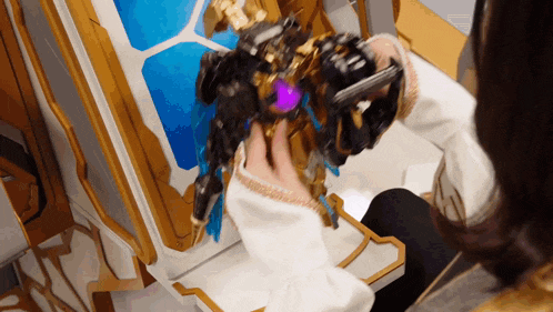 a person is playing with a toy robot that has a purple light on it