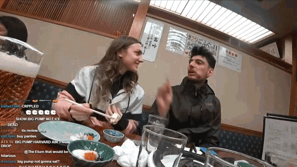 a man and a woman are sitting at a table with a sign behind them that says 29