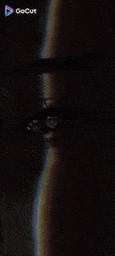 a close up of a woman 's eye with a rainbow behind it .