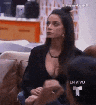 a woman in a black top is sitting on a couch talking to another woman .