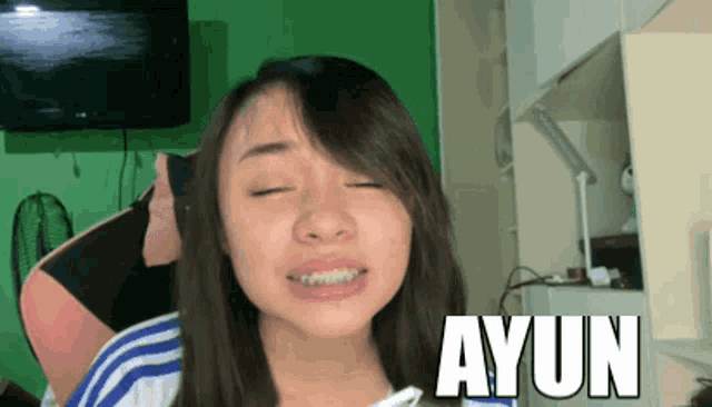 a woman with her eyes closed and ayun written on the bottom of her face