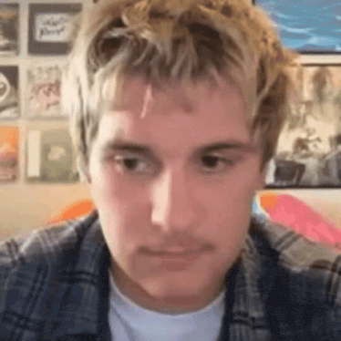 a close up of a man 's face with a plaid shirt