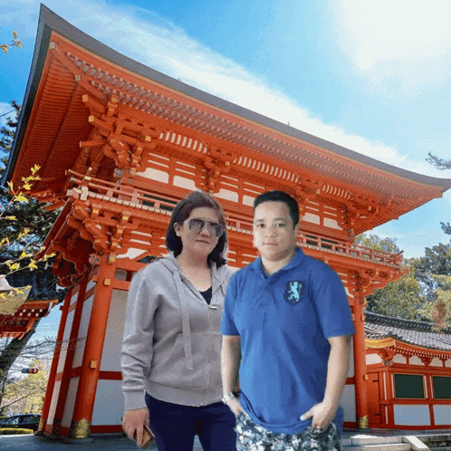a man wearing a blue shirt with a lion on it poses with a woman