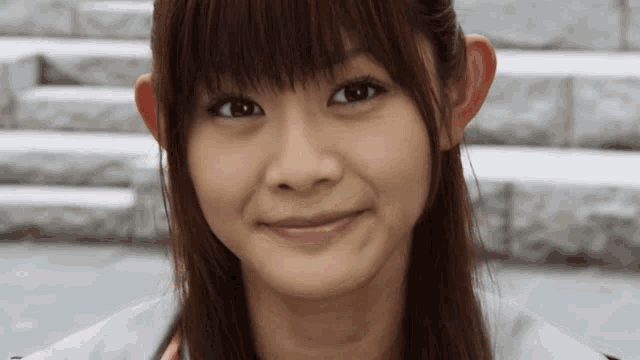 a close up of a woman 's face with a slight smile