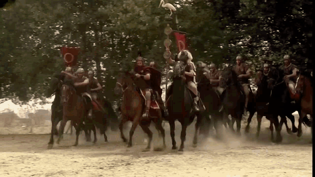 a group of men are riding horses with a flag that says o on it