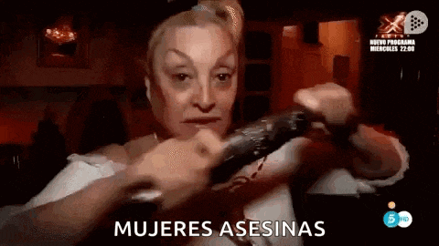 a woman is holding a remote control in her hand and saying mujeres asesinas .
