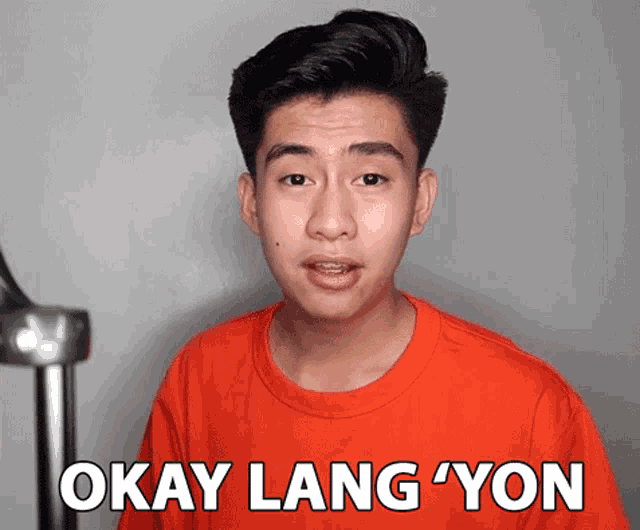 a man wearing an orange shirt says okay lang yon