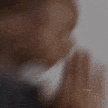 a blurry picture of a man praying with his hands folded in prayer .