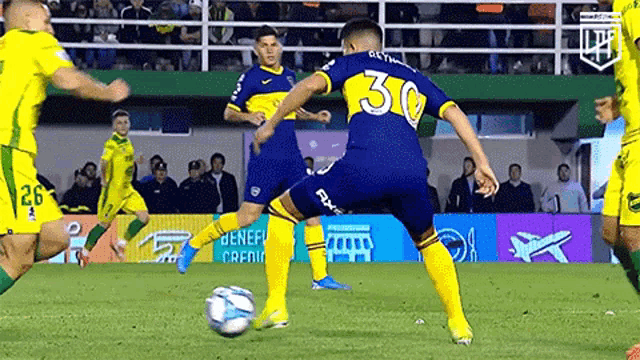 a soccer player with the number 30 on his jersey is kicking a soccer ball .