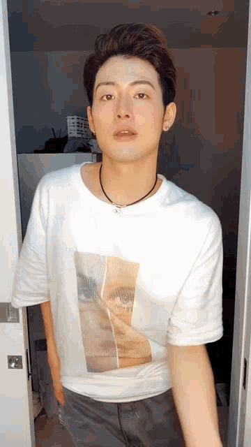 a young man is wearing a white t-shirt with a picture of a woman on it