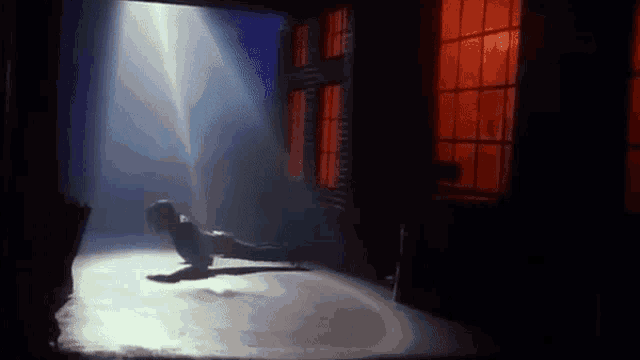 a man is laying on the floor in a dark room