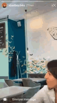 a woman is sitting at a table in a restaurant talking to someone .