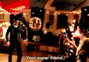 a man and woman are dancing in a room and the man is saying " your super friend .. "