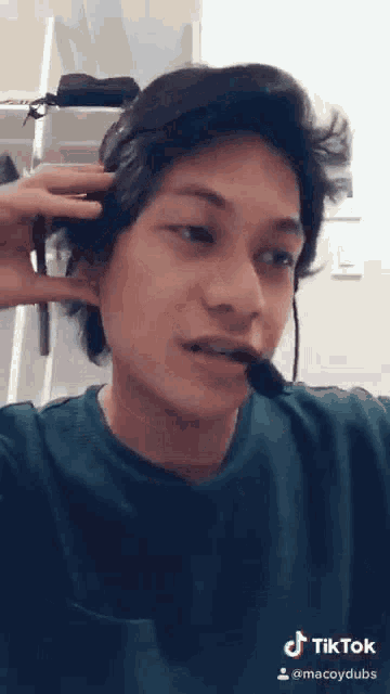 a young man is wearing a headset and a microphone .