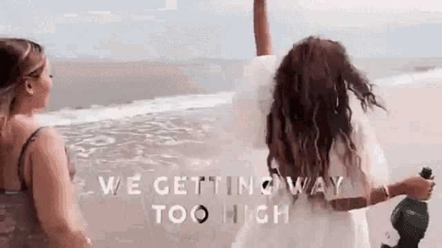 two women are standing on a beach with the words we getting way too high behind them