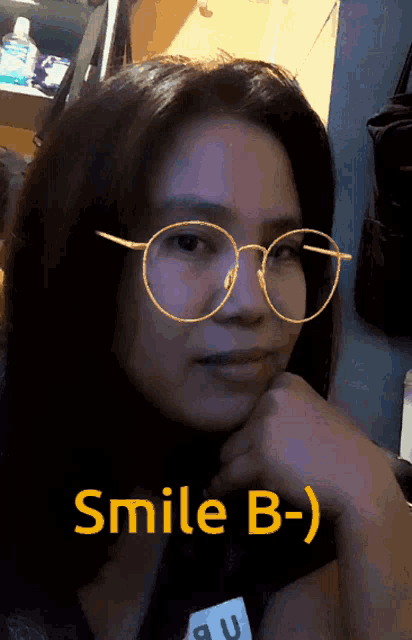 a woman wearing glasses and a name tag says smile b-