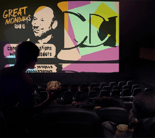 a group of people sitting in front of a large screen that says great mondays radio