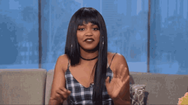 a woman sitting on a couch with her hands up