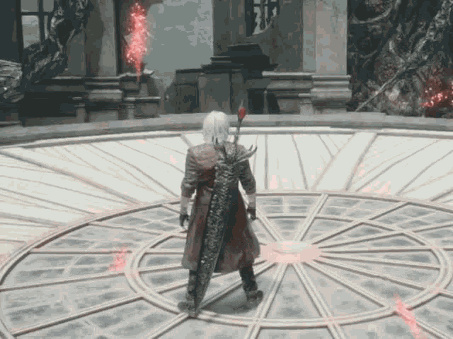a man in a red coat is standing in a circle in a video game holding a large sword .