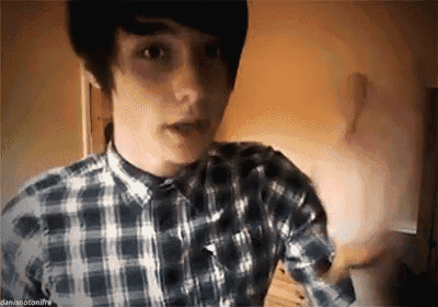 a young man wearing a plaid shirt is making a funny face