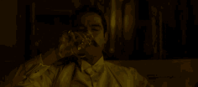 a man with a mustache drinks from a glass