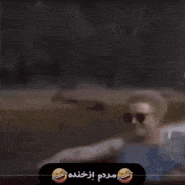 a blurred image of a person with a smiley face and a foreign language written on the bottom