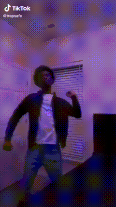 a man is dancing in a room with a purple wall and a purple ceiling .