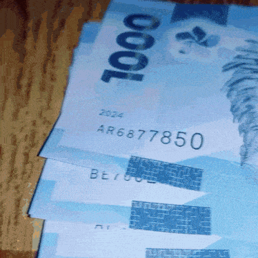 a close up of a stack of 1000 bills with ar6877850 on them
