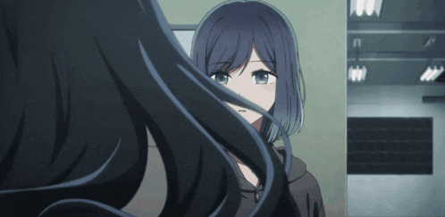 a girl with long black hair is looking at herself in the mirror