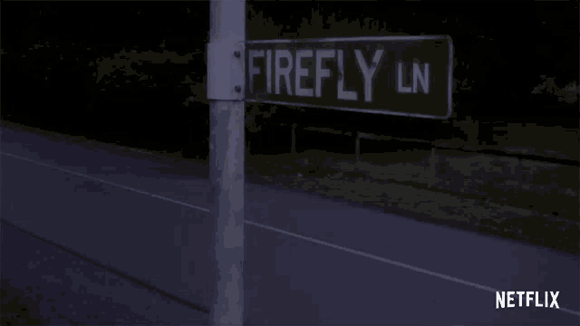 a street sign for firefly ln is on a pole next to a road