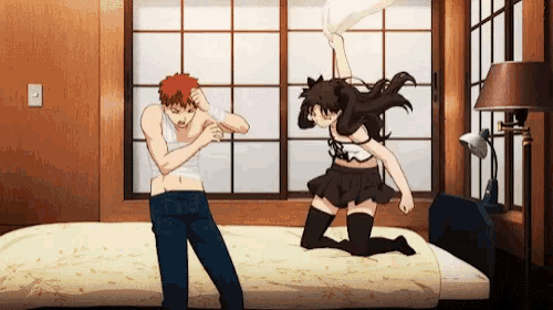 a man and a woman are having a pillow fight on a bed in a bedroom .