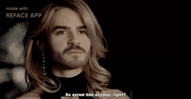 a man with long hair and a beard is wearing earrings and a black shirt .