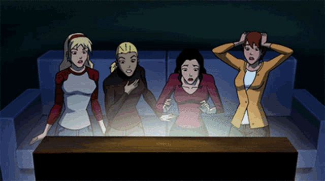 a group of women are sitting on a couch watching a tv