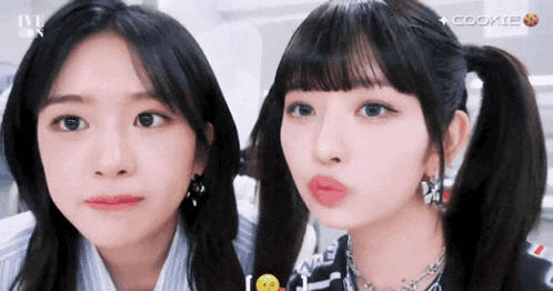 two girls are making funny faces in front of a sign that says cookie on it