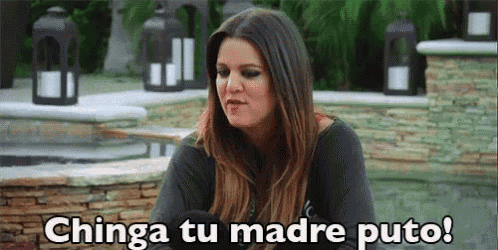 a woman is sitting in front of a brick wall and says chinga tu madre puto !