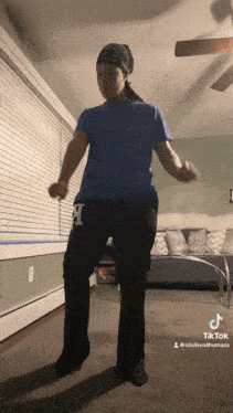 a person wearing a blue shirt and black pants with the letter l on them